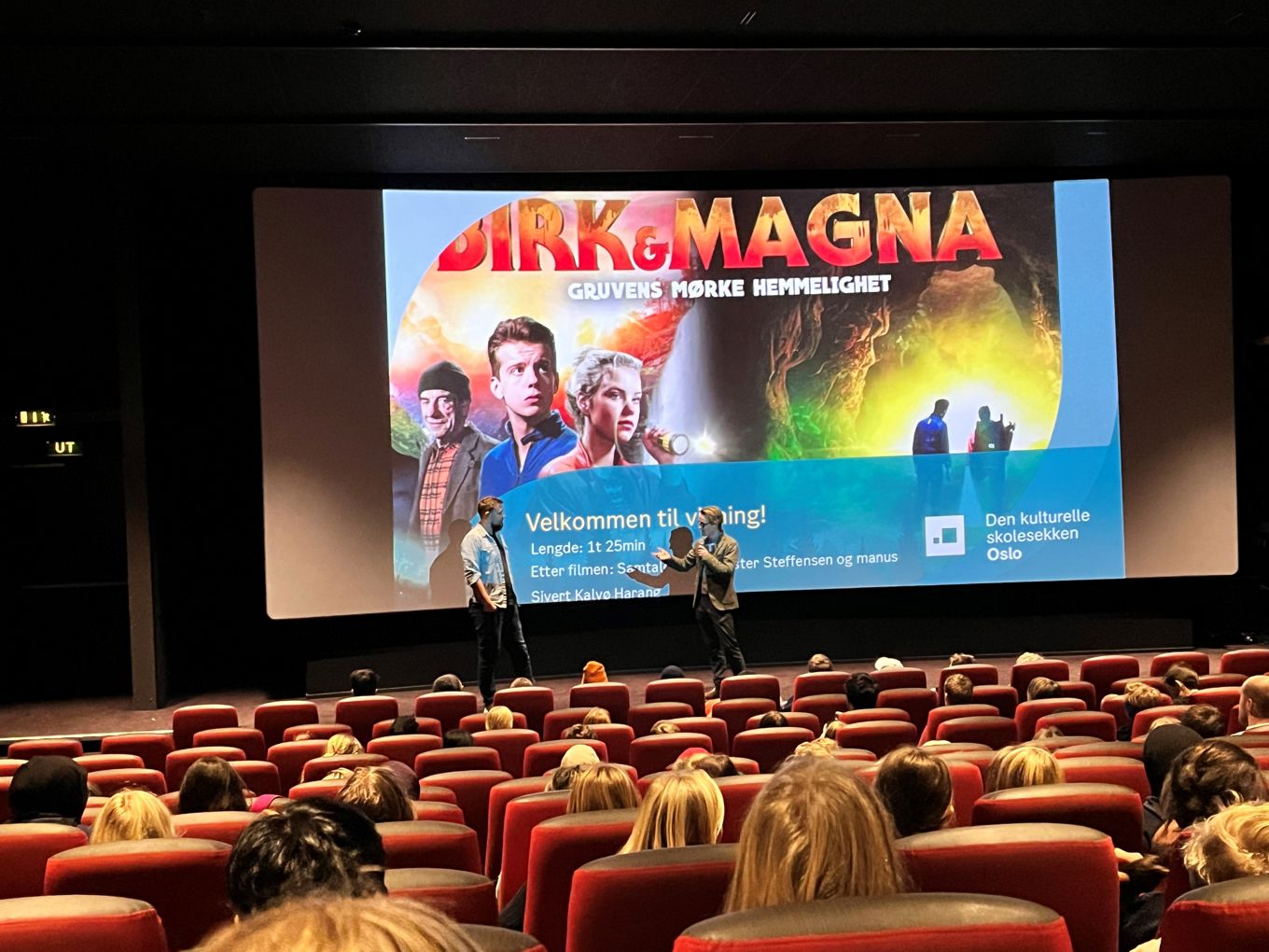 Foto: Beate S. Ranglund To mennesker på en scene med filmlerret i bakgrunnen
