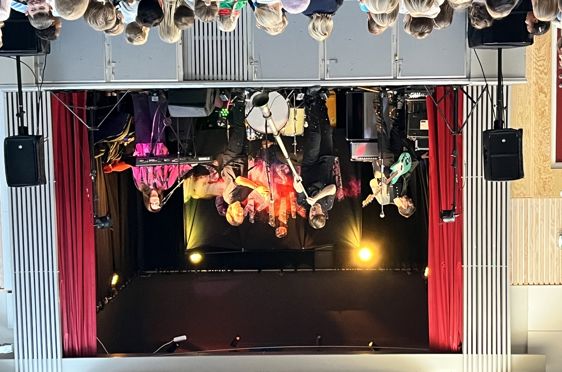 En gruppe mennesker på en scene med instrumenter