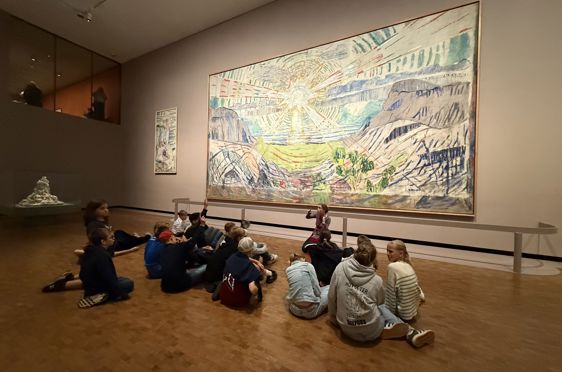 en gruppe mennesker som sitter foran et maleri av Munch
