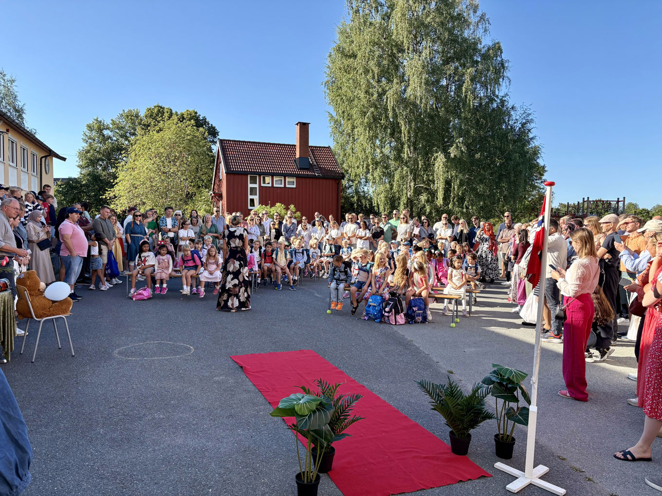En gruppe mennesker samlet i skolegård