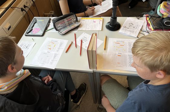en gruppe mennesker som sitter rundt et bord med papirer og blyanter