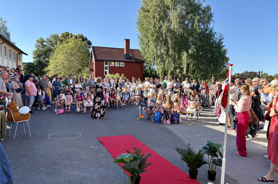 En gruppe mennesker samlet i skolegård