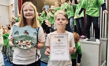 To barn som holder skilt og diplom