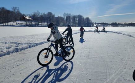 En gruppe mennesker som sykler på en snødekt vei