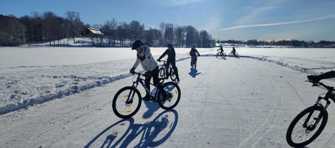 En gruppe mennesker som sykler på en snødekt vei